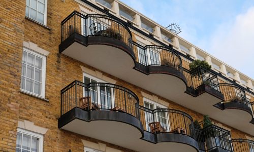 Exterior of modern yellow brick house. Architectural detail of close-up on windows, balconies. Exterior of modern yellow brick house. Architectural detail of close-up on windows, balconies.